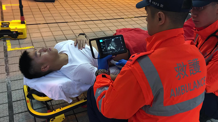 救护主任使用便携式超声波扫描器检测伤势，在现场即时作出适切的诊断。